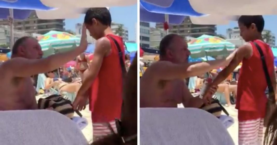Homem passa protector solar em menino que vendia bala na praia